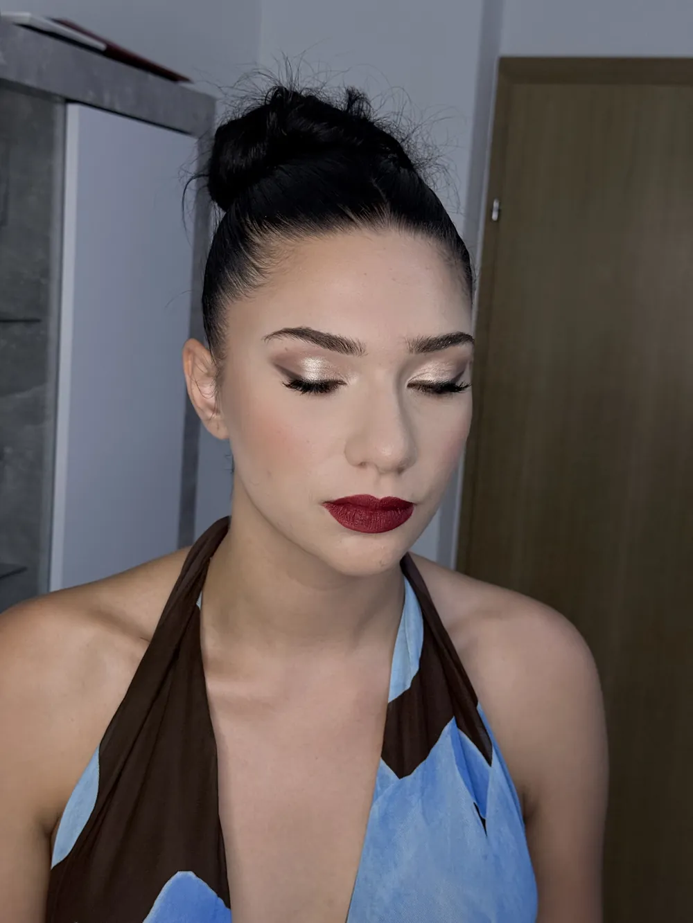Šminka s tamnocrvenim ružem i punđom, zatvorene oči